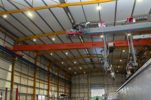 Overhead cranes and steel fabrication equipment in the workshop
